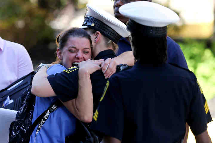 A woman, whose father was killed in a deadly shooting at Fountain Square, is comforted by authorities stationed outside the University of Cincinnati Medical Center's Emergency room following a mass shooting in downtown Cincinnati that left at least four dead and several injured, Thursday, Sept. 6, 2018, in Cincinnati.   (Kareem Elgazzar / The Cincinnati Enquirer)